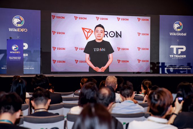 A virtual message from TRON founder Justin Sun, wearing a branded TRON t-shirt, is displayed on large screens at the Wiki Finance Expo Hong Kong 2026, where TRON received recognition as the Best Blockchain, flanked by WikiExpo, WikiGlobal, and TP Trader Academy logos.
