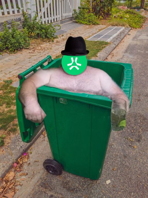 A green trash bin on a residential street with muscular arms resting on the rim, wearing a black fedora and a green face emoji with an angry expression.