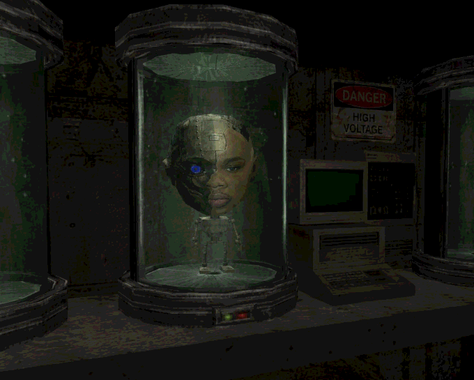 A dark, low-resolution rendering of a humanoid figure with a metallic/cyborg face and glowing blue eye contained inside a glass cylindrical chamber, with a 'DANGER HIGH VOLTAGE' sign visible.