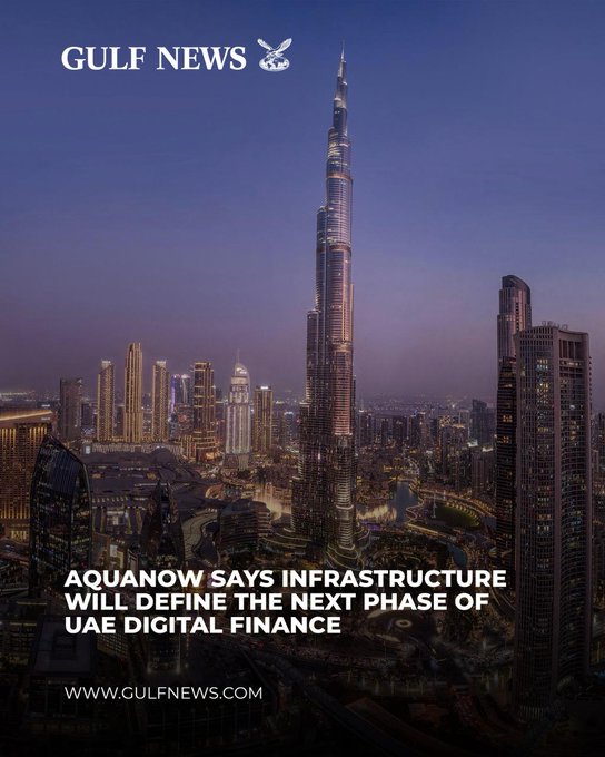 A Gulf News article headline reading 'AQUANOW SAYS INFRASTRUCTURE WILL DEFINE THE NEXT PHASE OF UAE DIGITAL FINANCE' displayed over an evening photograph of the Burj Khalifa and Dubai skyline.