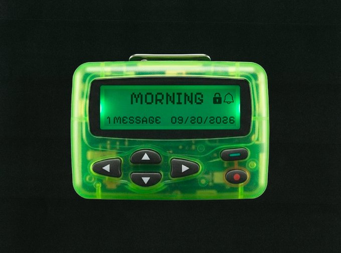 A retro-futuristic translucent green electronic device with an LCD screen displaying 'MORNING', '1 MESSAGE', and the date '09/20/2026', along with directional buttons on a black background.