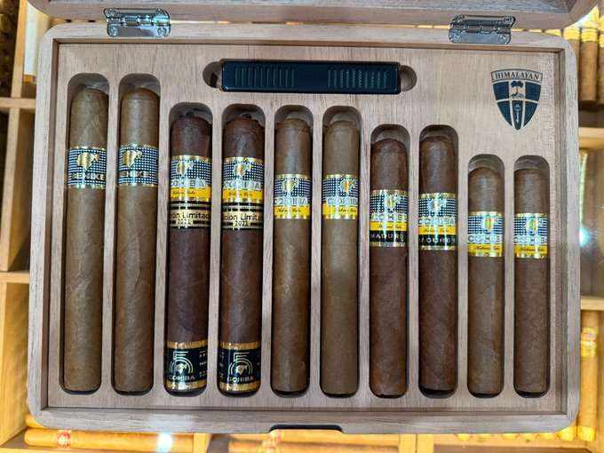 An open wooden cigar humidor containing an assortment of Cohiba cigars, featuring a humidity gauge and the Himalaya brand logo.