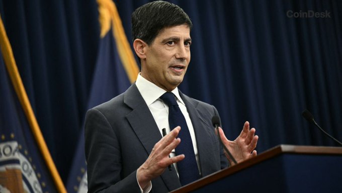 A man in a dark suit and tie speaks at a podium with microphones, gesturing with his hands, with a "CoinDesk" watermark visible and what appears to be a Federal Reserve seal in the background, illustrating the post about U.S. CPI data and Treasury yields.