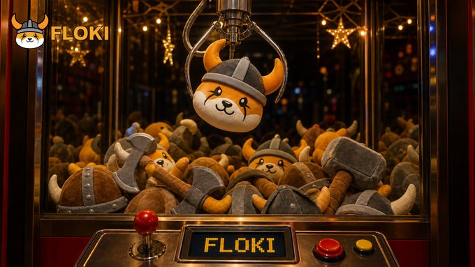 A claw machine filled with Viking-helmeted Shiba Inu plush toys, with one plush being lifted by the claw's golden hook, beneath a "FLOKI" logo and beside a machine also labeled "FLOKI." The image represents "the grand prize," symbolizing Floki as a coveted, valuable catch for crypto enthusiasts.