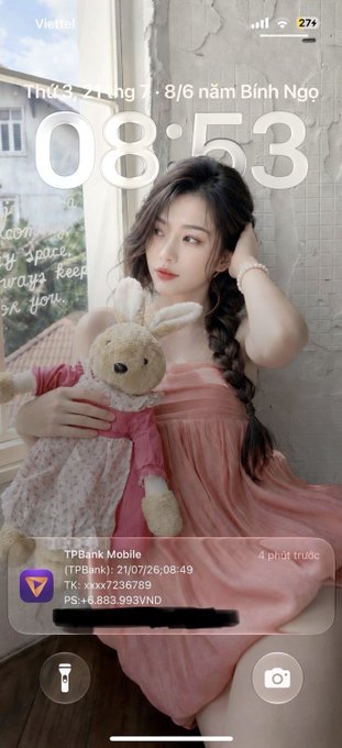 A young woman with a long braid, wearing a pink dress, poses with a stuffed bunny beside a window. Visible text shows a TPBank Mobile transaction of +8,236,789 VND and a balance of +6,883,993 VND, dated 21/07/26, suggesting she received income—tying into her post about earning opportunities through 𝕏 (Twitter) and Web3.