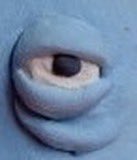 A plastic googly eye stares blankly, mocking the trader's desperation for high-MP (marketplace) NFTs as they realize "alpha groups" offer little real advantage over public trades.