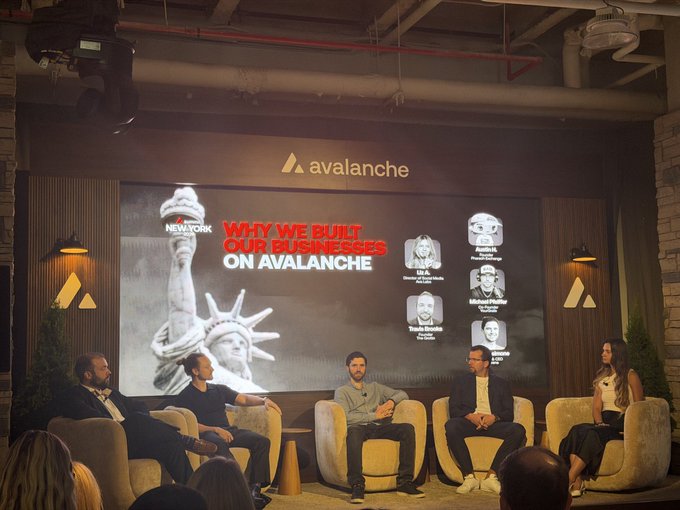 A live panel discussion at an Avalanche (AVAX) event features several founders seated on stage, with a presentation slide titled "WHY WE BUILT OUR BUSINESSES ON AVALANCHE" displaying the New York event branding and headshots of speakers, aligning with the post's highlights of insights from Avalanche project founders including YourGrails.
