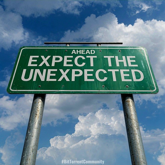 A green highway-style sign mounted on two metal poles reads "AHEAD EXPECT THE UNEXPECTED" against a cloudy blue sky, with a "#BitTorrentCommunity" watermark at the bottom.