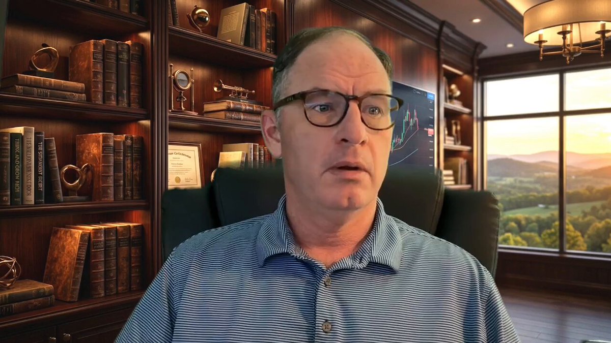 The image shows a man wearing glasses sitting at a desk with several books around him, suggesting he might be working or studying. The background features a window overlooking a beautiful landscape of mountains, providing a serene atmosphere for his work. The caption reads "The XRP Moment Is Real Watch The Full Youtube Video Here: youtu.be/hA5a8qL0xJE". This indicates that the image is related to an online video or article about XRP and its impact on the market, possibly discussing the man's thoughts or experiences with this digital currency.