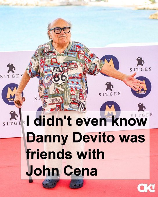 A photo shows actor Danny DeVito in a colorful Route 66 shirt at a Sitges event, with overlaid text reading "I didn't even know Danny Devito was friends with John Cena."