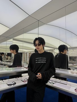 A stylish individual wearing sunglasses and a black sweatshirt printed with "LUCID NEW TO SELF / SOMETIMES / MY REFLECTION" poses in a modern glass-walled space, complementing the post's themes of self-reflection and the hashtags #ALPHADRIVEONE, #ALD1, #LEO, and #리오.