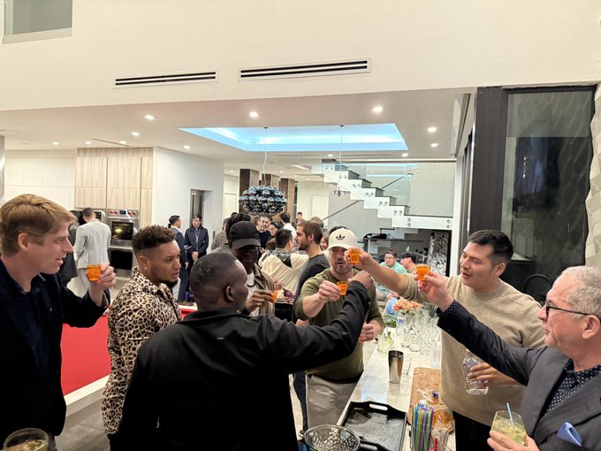 A lively gathering of investors and founders raising their glasses in a toast at the Infinite Alliance party in Miami, capturing the networking, big ideas, and celebratory spirit described in the post.