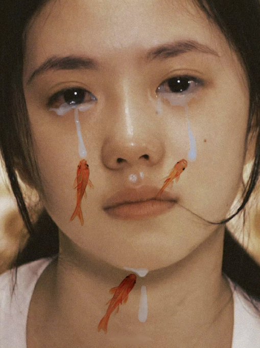 A surreal portrait of a young woman crying white tears with small orange goldfish appearing to drip from her eyes, nose, and chin.
