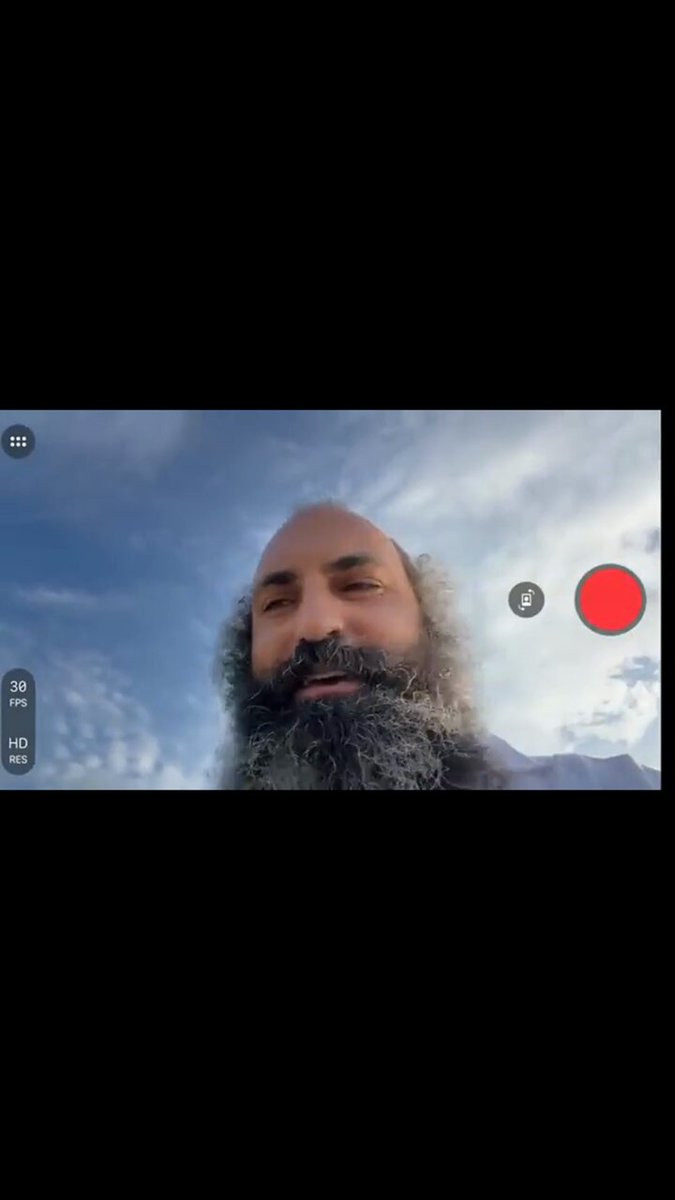 The image shows a bearded man with his chin resting on his hand, looking off-camera towards the camera while holding a red button in his right hand. The context appears to be related to Bitcoin prices, as there are text elements at the bottom of the image that say "Bitcoin still pulling back down to 64K I closed 70% of my stock portfolios." This may indicate that someone has been monitoring Bitcoin market trends and decided to close their investments.