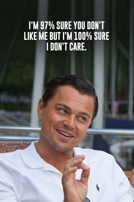 A man in a white polo shirt smiles warmly while making a small hand gesture, with text above reading "I'M 97% SURE YOU DON'T LIKE ME BUT I'M 100% SURE I DON'T CARE."

The image complements the cheerful "Gm… Happy Tuesday." message by pairing a relaxed, good-morning vibe with a lighthearted quip about not caring about others' opinions—setting a confident, carefree tone for the day.