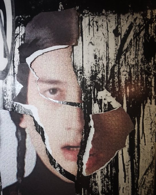 A torn and weathered poster showing a woman's face partially visible through ripped paper with dark streaks running down.