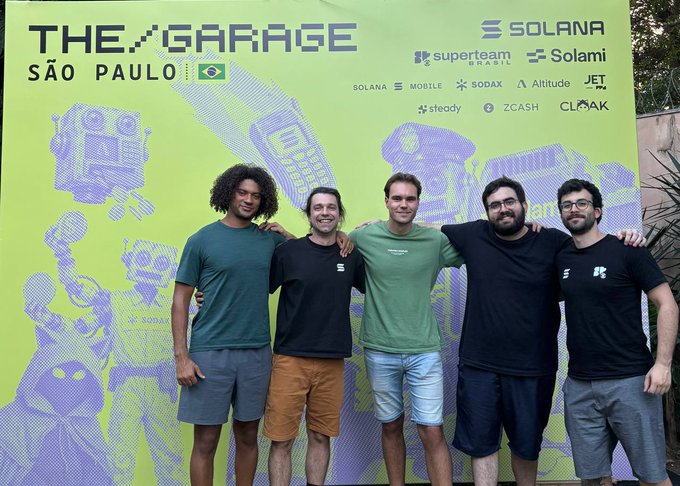 Five men stand arm-in-arm in front of a bright green backdrop promoting "THE GARAGE SÃO PAULO," featuring Solana and partner logos (Solami, SODAX, Altitude, JET, Steady, ZCASH, CLOAK), with one man wearing a shirt reading "Superteam Brazil" and another in a green tee labeled "SOLANA FOUNDATION." The image captures the team behind the Solana hackhouse event in Brazil that the post is referencing.