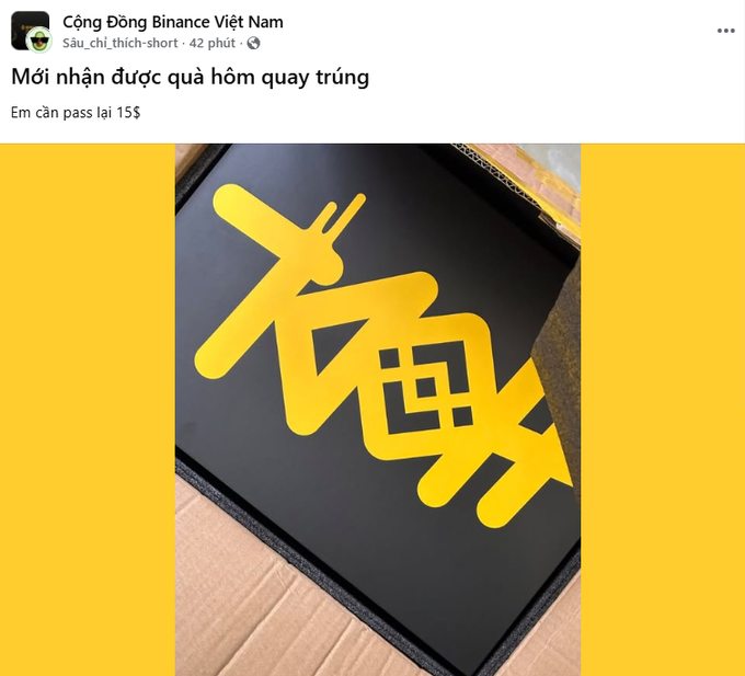 A Facebook post from 'Cộng Đồng Binance Việt Nam' shows a yellow sign with stylized Japanese text reading 'オリ曲' (Orikyoku), with the caption 'Mới nhận được quà hôm qua trúng / Em cần pass lại 15$' indicating a gift received from a previous contest.