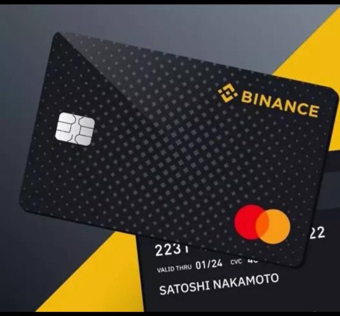 A black Binance cryptocurrency debit card with a gold logo and Mastercard symbol, labeled 'SATOSHI NAKAMOTO' as the cardholder, valid through 01/24.