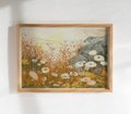A small framed painting depicting a giraffe in a savanna landscape with a mountain in the background.