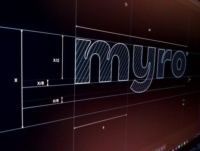 A close-up photo of a digital screen displaying the "myro" logo in a design grid with measurements like "x," "x/2," and "x/6" visible, likely showing the brand's design guidelines for an update on the MYRO project.