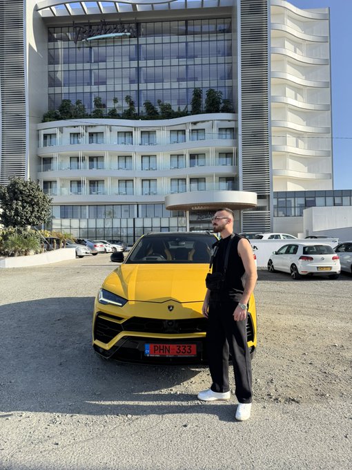 A man in all black stands proudly beside a bright yellow Lamborghini Urus with the license plate "PHN 333" parked in front of a modern glass building, projecting an image of luxury and success that visually parallels the post's bullish sentiment about Solana memes. The exotic sports car serves as a symbol of the wealth-generating potential the poster attributes to the upcoming "parabolic run" in Solana-based meme tokens.