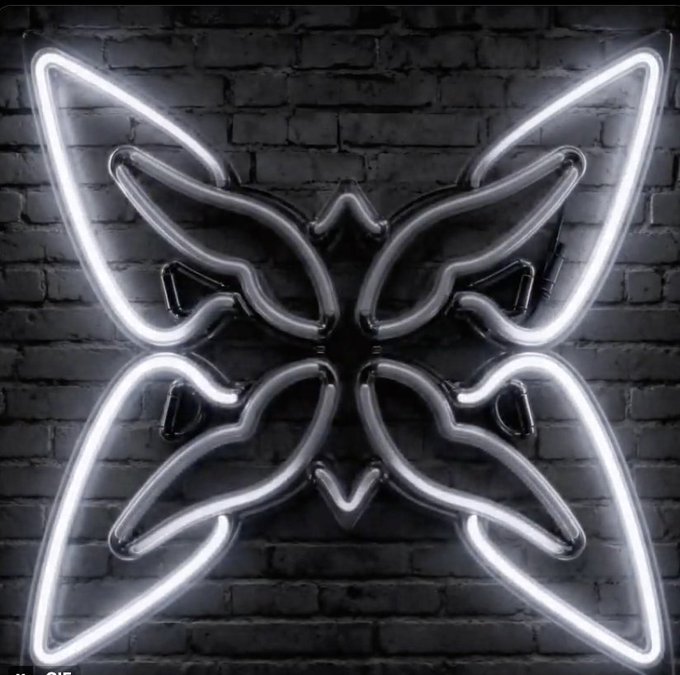 A glowing neon sign shaped like a butterfly is mounted on a dark brick wall, with light pink text visible in the bottom left corner.