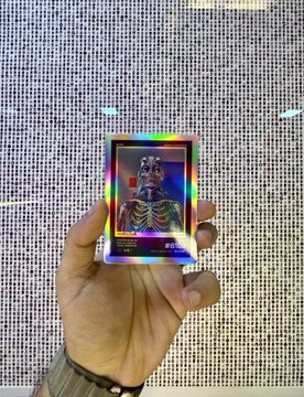 A hand holds up a shimmering holographic Beeple "Everydays 5000" collectible card with a rainbow prismatic finish, prominently featuring "BEEPLE" and "EVERYDAYS 5000" text along with the number "132." The caption "grails of grails" with mentions of a "Triple Error Card and Triple Boner Everydays 5000" highlights this as a rare and highly coveted Beeple NFT collectible piece.