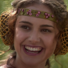 A woman wearing a floral headband smiles broadly with a wide, laughing expression, paired with the caption questioning whether sudden BTC price drops could really be from reckless 40x leveraged longs—her knowing, gleeful look fittingly conveying a mocking "sure, that must be exactly what's happening" sentiment.