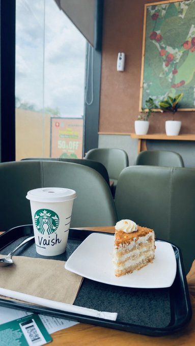 A Starbucks coffee cup labeled "Vaish" sits on a tray beside a slice of carrot cake at a quiet café, capturing a peaceful solo weekend break from trading screens. The handwritten name on the cup personalizes the calm moment, echoing the post's reflective "touching grass" vibe after a tough day in the markets.