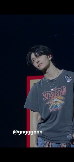A young man with dark hair wearing a gray 'STARROAD' graphic t-shirt is shown at what appears to be a concert, with the watermark '@gngggnnn' displayed.