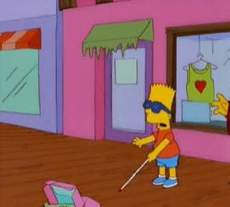 A Simpsons cartoon scene showing Bart Simpson wearing sunglasses and holding a white cane, walking past storefronts with a 'Kwik-E-Mart' visible.
