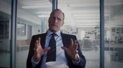 A man in a suit gestures with both hands while speaking in what appears to be an office or corporate setting. No text, numbers, tickers, or names are visible in the image, and the scene appears to be unrelated to the accompanying post about "bip110 stops csam."