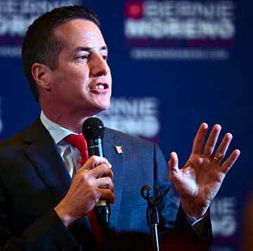 A man in a dark suit and red tie speaks into a microphone at a podium, gesturing with his hand while standing in front of a "BERNIE MORENO" campaign backdrop.

The image does not relate to the post, which discusses XRP cryptocurrency and an upcoming Tuesday event for the XRP Army; the photo instead shows a political candidate speaking at a campaign event.