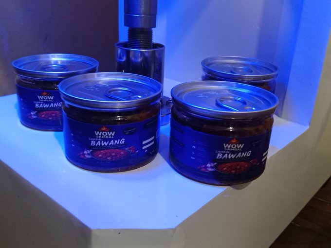 Several jars of "WOW CHICKEN BAWANG" chili sauce are displayed on a white shelf under blue lighting.