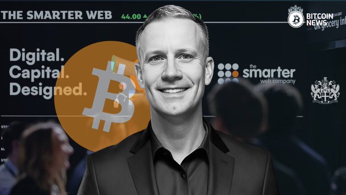 A smiling man in a black shirt and blazer stands in front of a backdrop featuring "THE SMARTER WEB" banner, a Bitcoin logo, the company's logo, and a "BITCOIN NEWS Society Intl" badge, promoting the launch of their "MORE" preferred share IPO offering 277,777 shares at £90 each with 12% annual dividends.