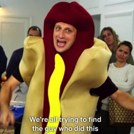 A man wearing a hot dog costume enthusiastically exclaims "We're all trying to find the guy who did this," with shocked onlookers behind him, humorously illustrating the post about someone who made a bold trade dumping $40k of $TENDies to buy $Jimothy at all-time highs.