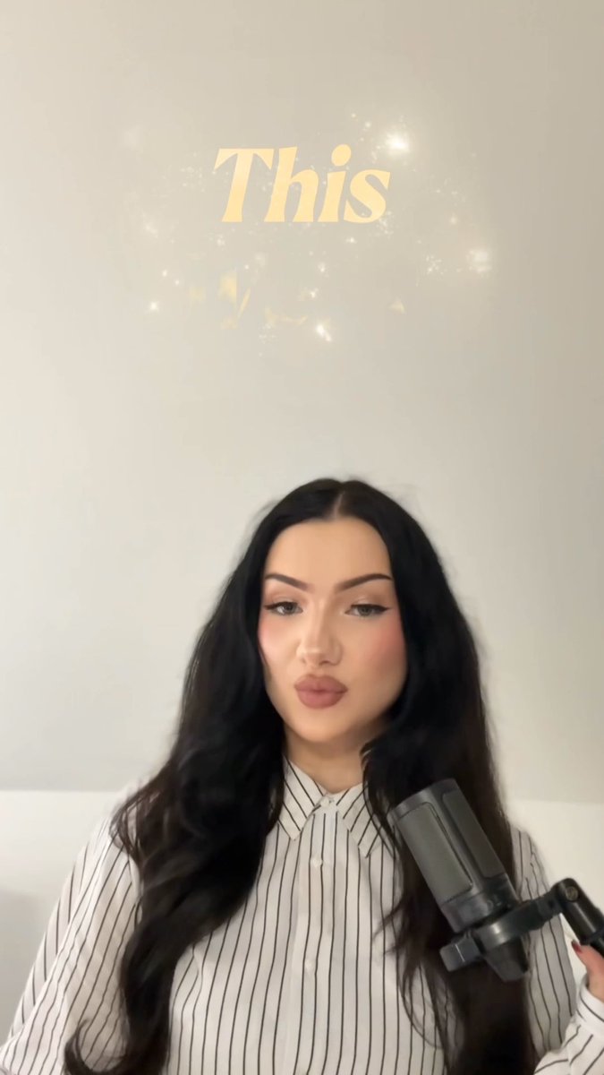 A woman with long dark hair wearing a striped shirt speaks into a microphone, with the word 'This' displayed above her amid a sparkle effect.