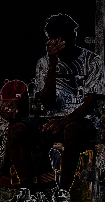 A heavily darkened, high-contrast image shows two figures, one wearing a red baseball cap and the other holding a hand to their face, with stylized outlines and neon accents.