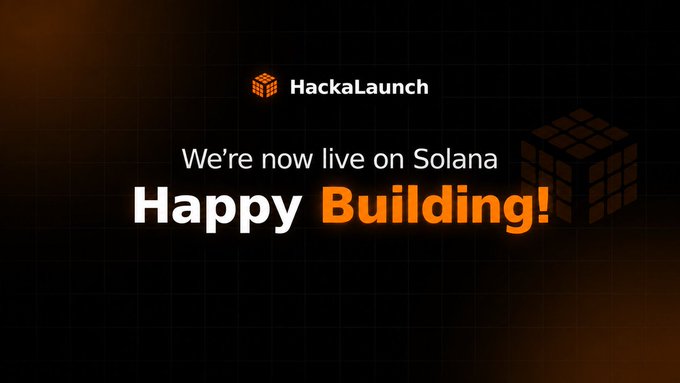 A promotional graphic with a dark grid background features the HackaLaunch logo at the top, alongside a 3D Rubik's cube illustration in orange and black. The text reads "We're now live on Solana" followed by "Happy Building!" in bold orange and white lettering, announcing the platform's launch on the Solana blockchain.