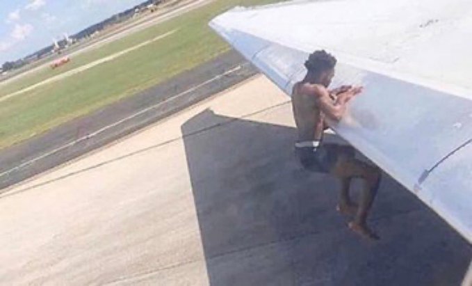 The image captures a daring scene of a shirtless man clinging to the wing of an airplane as it taxis on the runway. This surreal, gravity-defying moment visually mirrors the post's metaphor of "taking flight" on Solana and memecoins, with Ansem as the fearless trader riding the volatile crypto rally while bears remain grounded.