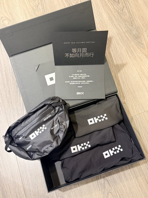 An open black OKX-branded gift box contains pouches and items, accompanied by a card reading 'HAPPY MID AUTUMN FESTIVAL' in both English and Chinese characters.