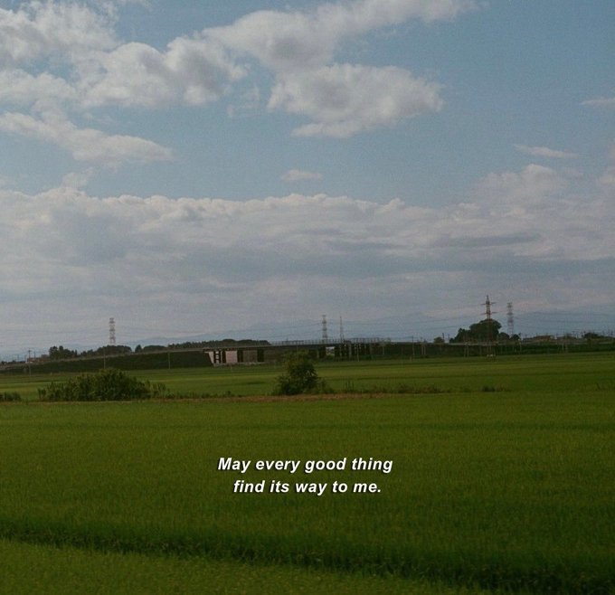 A scenic landscape showing a green field under a blue cloudy sky, with the text "May every good thing find its way to me." overlaid at the bottom.