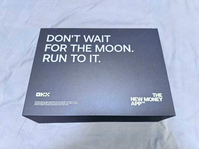A black OKX-branded gift box with the slogan "DON'T WAIT FOR THE MOON. RUN TO IT." and "THE NEW MONEY APP" text sits on a white surface, matching the Mid-Autumn Festival promotional gift from OKX mentioned in the post.