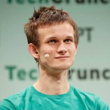 A young man with spiky brown hair wearing a teal shirt and an earpiece microphone, appearing at what looks like a TechCrunch event based on the partially visible background text.