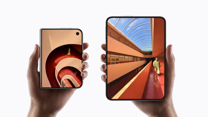 Two hands hold a smaller foldable smartphone (left, closed with its cover screen displaying a curved orange architectural design) and a larger unfolded device (right, showing a vibrant scene of a person walking through an orange-hued tunnel). The image visually illustrates the joke's premise about using the 7.6-inch inner display of the foldable phone for trading memecoins.