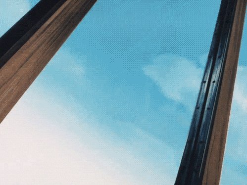 The image shows a blue sky with white clouds from a slightly elevated perspective, making up the background of the image. The two large wooden beams that run diagonally across the center of the photo are positioned at different heights, creating an interesting visual effect in the scene. At the bottom right corner, there is text written by someone who has purchased this item and is willing to sell it for 843.706 Bitcoins.