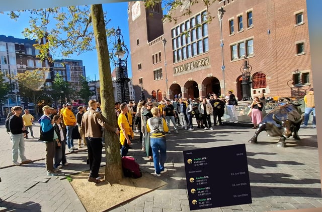 A group of people gathers in a sunny Amsterdam square near a bronze bull statue, likely during the 9th Mainnet event, with an on-screen portfolio tracker showing four SPX6900 (SPX) positions accumulated over 482 days via dollar-cost averaging. The caption celebrates the long-term DCA strategy and ties it to the celebratory Amsterdam meetup.
