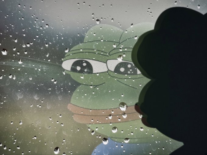 A melancholic photograph of a sad green Pepe the Frog meme character viewed through a rain-covered window, with a dark silhouette in the foreground.
