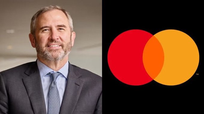 A man in a gray suit and blue tie stands next to the red and orange overlapping circles of the Mastercard logo on a black background.